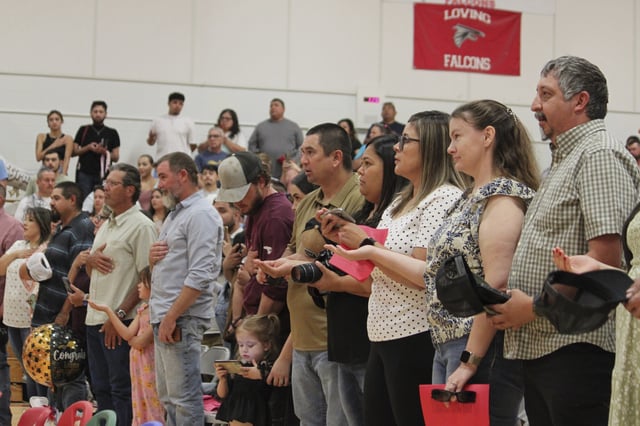 Family and friends recite the New Mexico state flag pledge ahead of a kindergartens' graduation ceremony at the elementary school in Loving, N.M., on Tuesday, May 20, 2025. (AP Photo/Susan Montoya Bryan)
