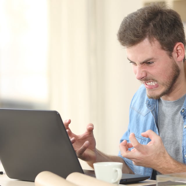 A man getting angry with his laptop.