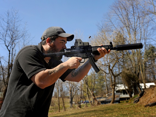 There's burst of smoke and ejecting shell as A.J. Wynne shoots a Heckler & Koch MP 5 short barrel rifle with a suppressor. A.J. Wynne is a former Marine who now works as a firearms instructor. He spent the afternoon target practicing with a variety of high-power weapons at a shooting range owned by the company he works for. He has strong opinions about what he thinks are government attempts to curtail the rights of gun owners. He has suffered from symptoms of PTSD in the past. Photo by (Michael S. Williamson/The Washington Post via Getty)