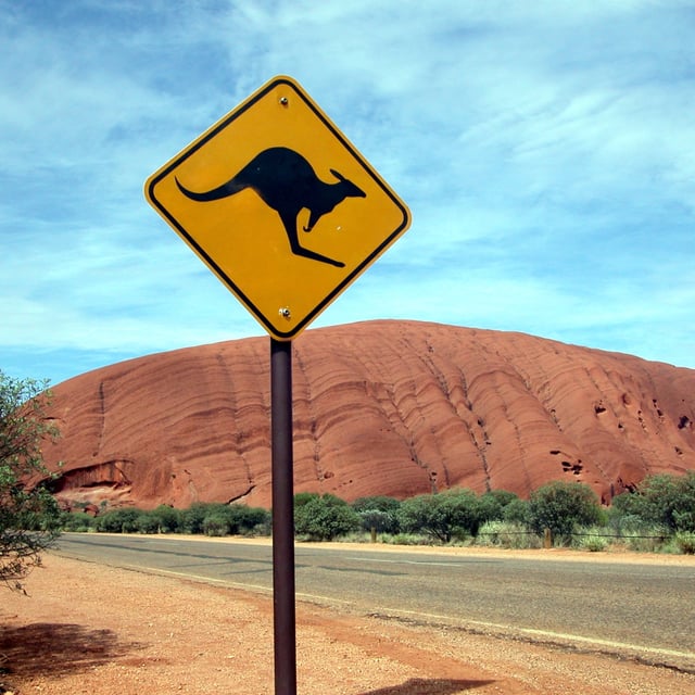 a kangaroo sign in front of a scenic desert scene