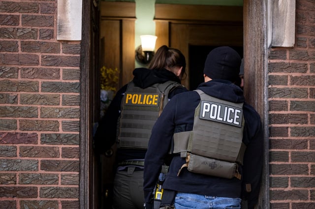 US Immigration and Customs Enforcement agents enter an apartment building during a multi-agency targeted enforcement operation in Chicago on January 26.