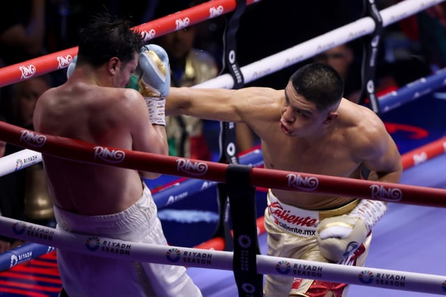 Mexico's Jaime Munguia (R) lands a punch on France's Bruno Surace during their super middleweight fight in Riyadh
