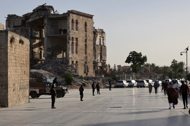 Des membres des forces de sécurité gardent les environs avant que le président intérimaire syrien Ahmed al-Shara assiste à la célébration "Alep, clé de la victoire" marquant la libération de la Syrie, à Alep, le 27 mai 2025.