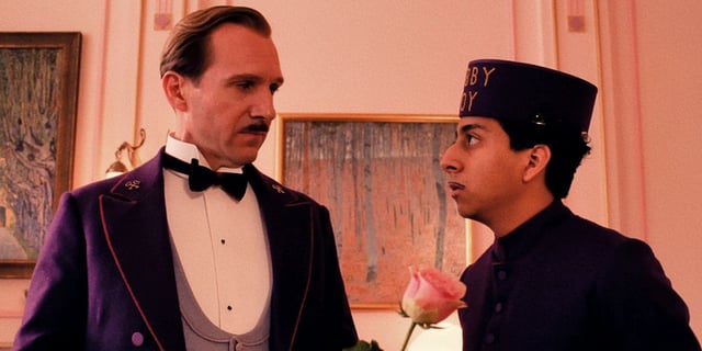 Ralph Fiennes as M. Gustave and Tony Revolori as Zero looking at each other in The Grand Budapest Hotel. 