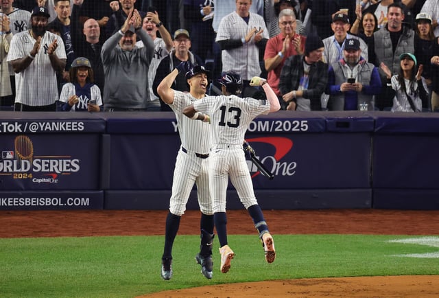 NEW YORK, NEW YORK - OCTOBER 30: Jazz Chisholm Jr. #13 of the New York Yankees is congratulated by Giancarlo Stanton #27 after hitting a solo home run during the first inning of Game Five of the 2024 World Series against the Los Angeles Dodgers at Yankee Stadium on October 30, 2024 in the Bronx borough of New York City.
