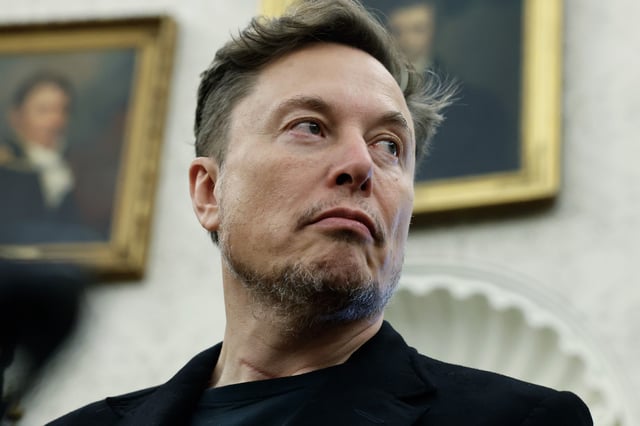Elon Musk listens as reporters ask U.S. President Donald Trump and South Africa President Cyril Ramaphosa questions during a press availability in the Oval Office at the White House on May 21, 2025 in Washington, DC.