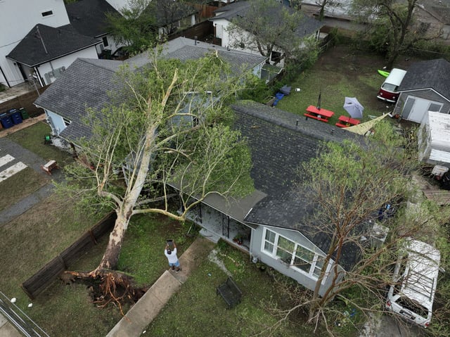 Charles White looks at the damage to his rental property on Leslie Avenue in East Austin, Thursday, May 29, 2025, after a large tree fell during a storm Wednesday. “We’ve never seen anything like this,” said White, who has lived in the neighborhood his whole life.