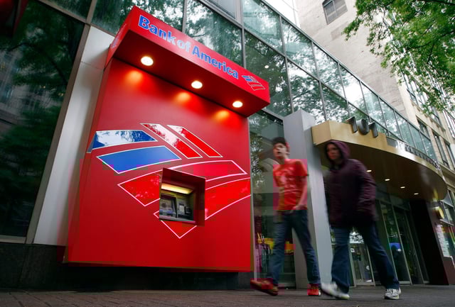 Pedestrians walk past a Bank of America ATM in Charlotte, North Carolina.