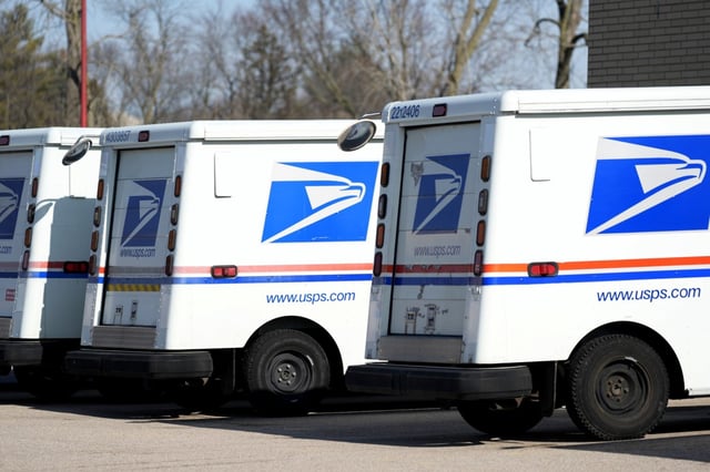 FILE – U.S. Postal Service trucks park outside a post office, Jan. 29, 2024, in Wheeling, Ill. The USPS signaled plans Tuesday, April 9, 2024, for a rate increase that includes hiking the cost of a first-class stamp from 68 cents to 73 cents, (AP Photo/Nam Y. Huh, File)