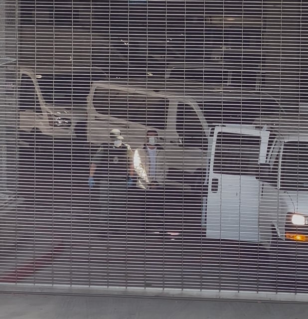An immigration agent escorts a man in shackles into a government vehicle at the ICE processing center in downtown Los Angeles on Friday, May 23, 2025. Last week the Trump administration escalated mass deportation efforts by having ICE agents arrest people, whose cases has been dismissed, after they walked out of immigration court. (Ryanne Mena)