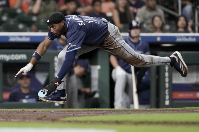 Tampa Bay Rays Chandler Simpson (14) scores on a throwing error by Houston Astros catcher Yainer Diaz as Simpson stole third during the fourth inning of an MLB baseball game in Houston, Thursday, May 29, 2025.