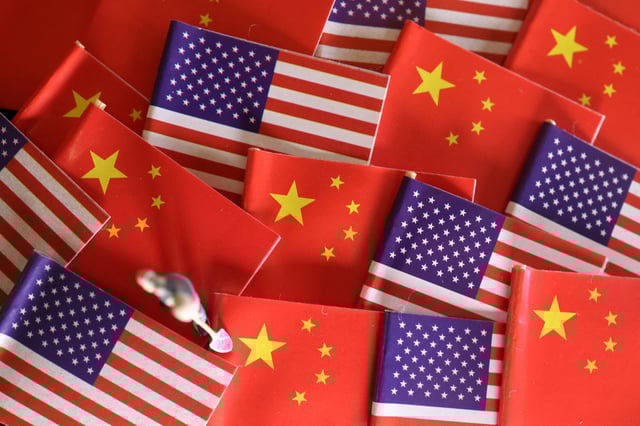 China and U.S. flags are displayed alongside a miniature worker in this illustration picture taken November 7, 2024. REUTERS/Florence Lo/Illustration