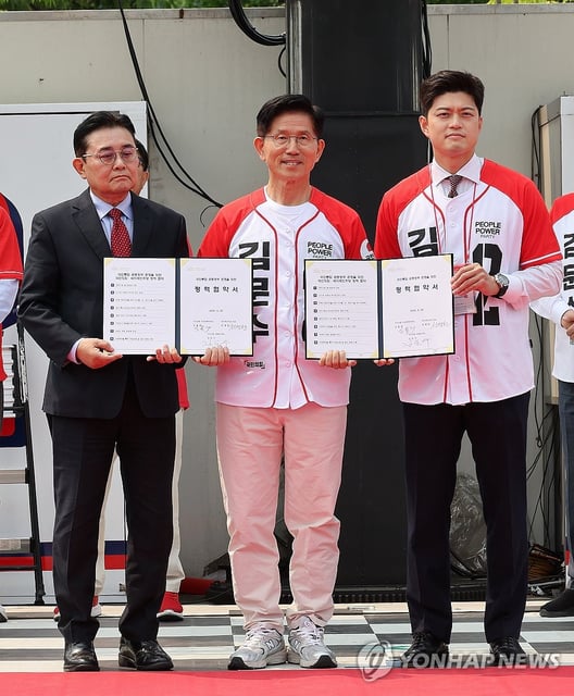 Kim Moon-soo (C), the candidate of the People Power Party for the June 3 presidential election, and the party's interim leader Kim Yong-tae (R) pose for a photo with Jun Byung-hun, head of the minor New Future Democratic Party, after forming a pact on a policy alliance between the parties during a campaign stop in Gapyeong, east of Seoul, on May 30, 2025. (Yonhap)