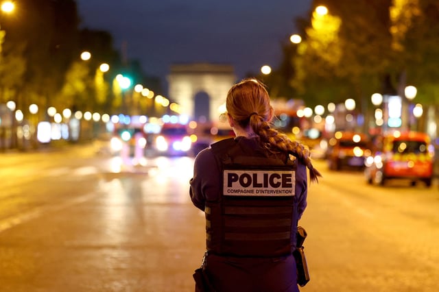 A Police officer stands guard on the Champs Elysees avenue, next to the Arc de Triomphe, in Paris, France, April 26, 2025. REUTERS/Abdul Saboor/File Photo