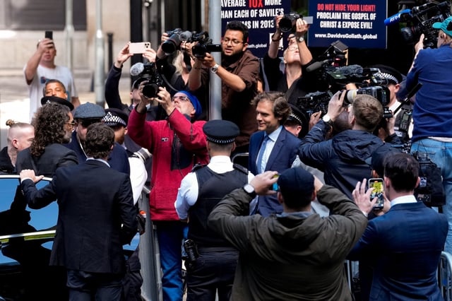 Members of the media surround British actor and comedian Russell Brand, who has been charged with rape and multiple counts of sex assault, outside Southwark Crown Court, in London, Britain, May 30, 2025. REUTERS/Carlos Jasso