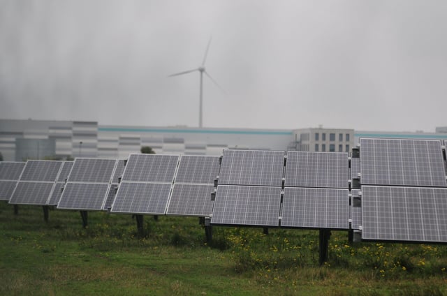 Photovoltaikmodule stehen in einem Gewerbepark in Bitterfeld-Wolfen. Im Hintergrund sind Gewerbegebäude zu sehen. Das Solarunternehmen Meyer Burger und Mittelstandsverband haben eine Solarallianz gegründet.
