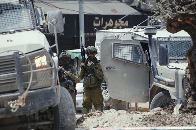 Israeli armored vehicles and soldiers are stationed in central Jenin, West Bank on Tuesday.