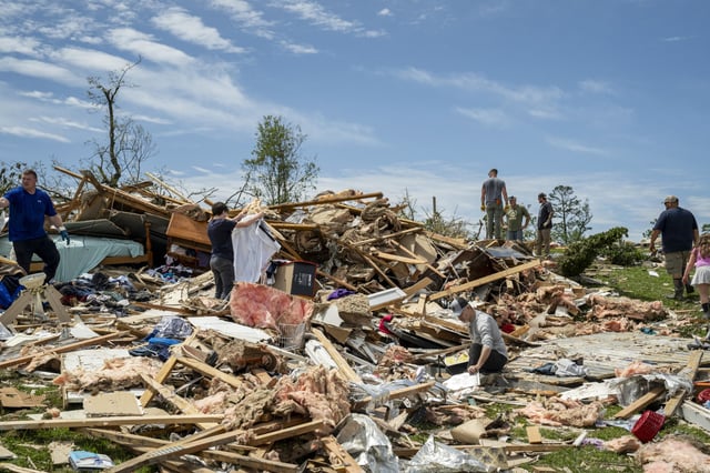 People look through the debris of a house in the community of Sunshine Hills outside of London, Ky., on May 18, 2025.