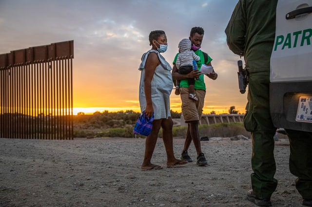 A Haitian family, including a mother-to-be boards a U.S. Border Patrol van to be taken to a processing center after they crossed the U.S.-Mexico border on Dec. 10, 2021 in Yuma, Ariz.