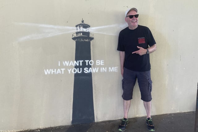A man poses by an artwork by street artist Banksy, Friday, May 30, 2025 in Marseille, southern France. (AP Photo/Bishr Eltoni)
