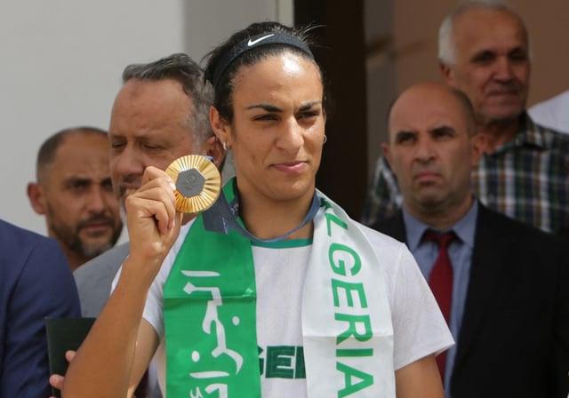 Algerian boxer Imane Khelif, who won the gold medal in the women's welterweight boxing at the Olympics, holds her medal upon her arrival at the airport in Algiers, Algeria  August 12, 2024. REUTERS/Ramzi Boudina/File Photo