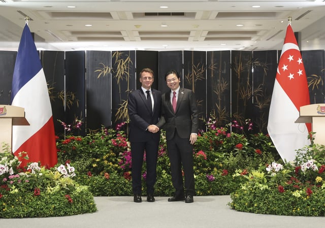 French President Emmanuel Macron (left) shakes hands with Singaporean President Lawrence Wong during a joint press conference after the signing of several bilateral agreements in Singapore on May 30, 2025.