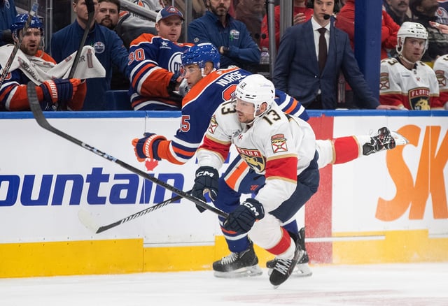 Florida Panthers Sam Reinhart (13) is checked by Edmonton Oilers' Darnell Nurse (25) during first period NHL action in Edmonton on Monday, December 16, 2024. 
