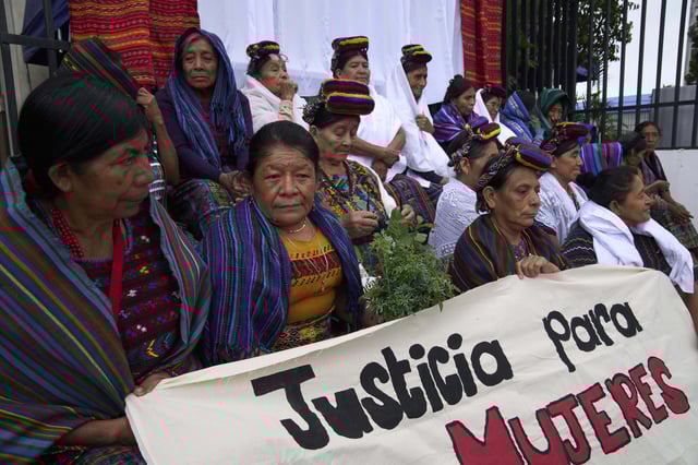 Indigenous women hold the sign in Spanish "Justice for women" outside the Supreme Court as they wait for an expected ruling, by a different court, in a case against three former paramilitary fighters who were trained by the military and are accused of raping 36 women four decades ago during Guatemala's civil war, in Guatemala City, Friday, May 30, 2025. (AP Photo/Moises Castillo)