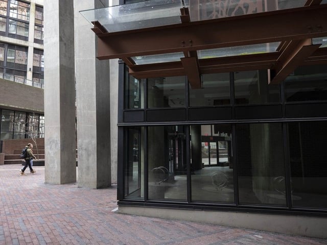 People walk past the empty JJ Beans coffee shop at the Woodward's building in Vancouver.