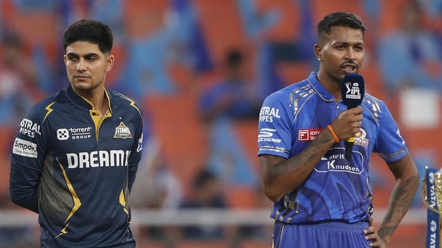 Gujarat Titans' captain Shubman Gill, left, looks away as Mumbai Indians' captain Hardik Pandya speaks