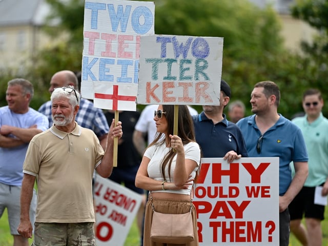 Protesters hold placards during a 'Enough is Enough' demonstration called by far-right activists near a hotel housing asylum seekers in Aldershot on August 4, 2024. Far-right protesters clashed with British police during tense rallies as unrest linked to disinformation about a mass stabbing that killed three young girls spread across the UK. (Photo by JUSTIN TALLIS / AFP) (Photo by JUSTIN TALLIS/AFP via Getty Images)