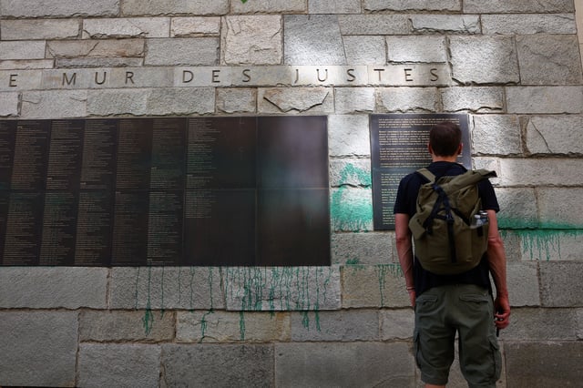 A man looks at 'The Wall of the Righteous' which honours people who saved Jews during the Nazi occupation of France, after it was covered in green paint, in Paris, France, May 31, 2025. REUTERS/Abdul Saboor