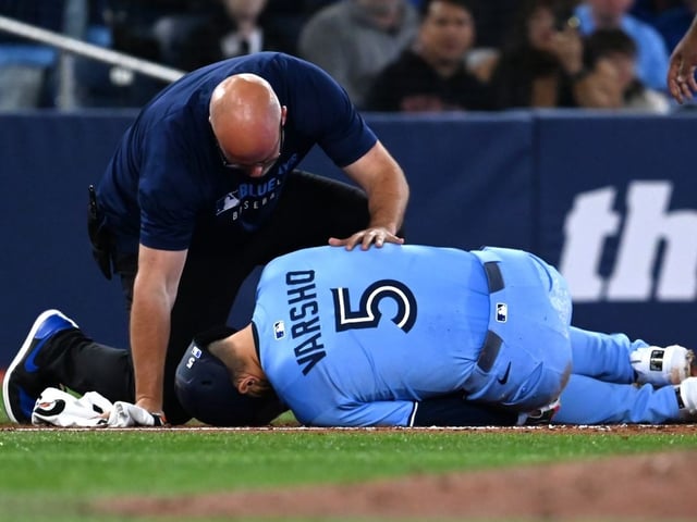 Blue Jays centre-fielder Daulton Varsho (5) is looked at by a team trainer after being injured while running the bases in the third inning of a Major League Baseball game in Toronto on Saturday, May 31, 2025.