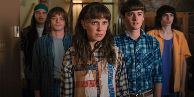 Eduardo Franco, Charlie Heaton, Millie Bobby Brown, Noah Schnapp and Finn Wolfhard in Stranger things season 4Eleven flanked by her friends, all looking at something off camera seriously, in Stranger Things