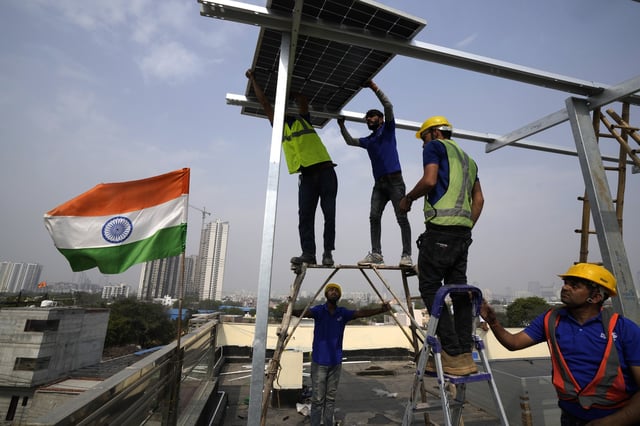 FILE - Workers of Solar Square place a panel on the rooftop of a residence in Gurugram on the outskirts of New Delhi, India, Feb. 20, 2024. (AP Photo/Manish Swarup, File)