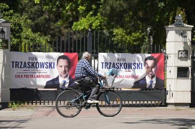 A man rides a bicycle past presidential campaign posters for liberal Warsaw mayor Rafal Trzaskowski on Friday May 30, 2025, in Lomianki, near Warsaw, Poland. (AP Photo/Czarek Sokolowski)