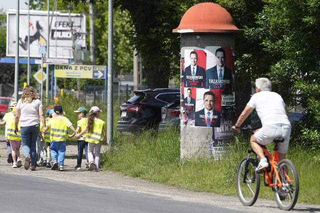 A man rides a bicycle past presidential campaign posters for liberal Warsaw mayor Rafal Trzaskowski on Friday May 30, 2025, in Dziekanow Lesny , near Warsaw Poland. (AP Photo/Czarek Sokolowski)