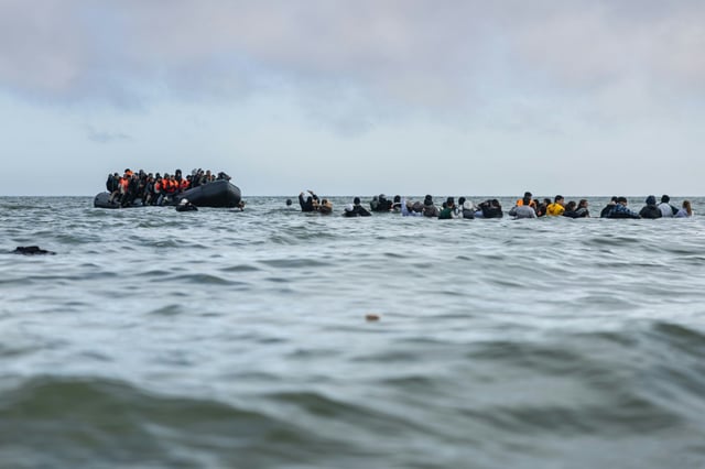 Des migrants embarquent à bord d'un bateau pour tenter de traverser la Manche, le 26 mars 2025 au large de la plage de Gravelines, dans le nord de la France