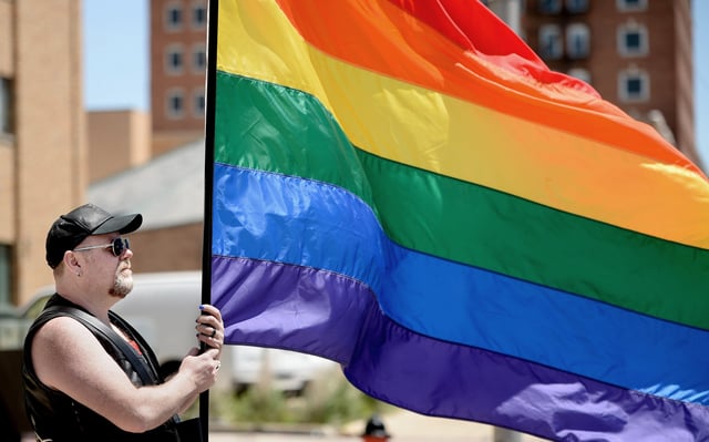 Matthew Cruse-Mauldin holds a Pride flag at Pridefest on Saturday, May 17, 2025 in Springfield, Illinois.