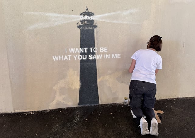 Agnès Perrone répare une œuvre de Banksy après son vandalisme nocturne à Marseille, le 1er juin 2025.