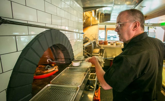 Chef Bruce Hill cooks wood-oven roasted chicken, one of his signature dishes, at Fog City in September 2013. The diner’s neon signs and bold, globally inspired menu helped cement its place in San Francisco’s culinary lore.
 