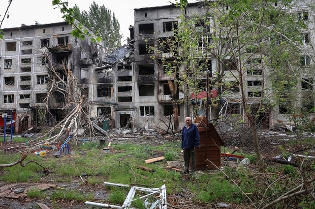 A resident stands near buildings damaged by Russian military strikes in the front line town of Myrnohrad, Donetsk region, Ukraine, on Thursday.