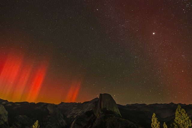 The northern lights, also known as the aurora borealis, glow over Half Dome in Yosemite National Park in October 2024. The northern lights could appear over portions of California on Sunday night.