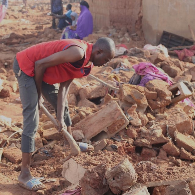 A man searches the rubble in a flooded area after heavy rainfall in the market town of Mokwa, north-central Nigeria, Saturday May 31, 2025. (AP Photo/Usman Salihu Mokwa)