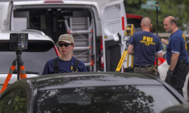Members of the FBI Evidence Response Team use measuring devices to document the crime scene as Annapolis Police and other law enforcement officials gather evidence on Monday, June, 12, 2023, in Annapolis, Maryland, after a shooting on Sunday that left three people dead.