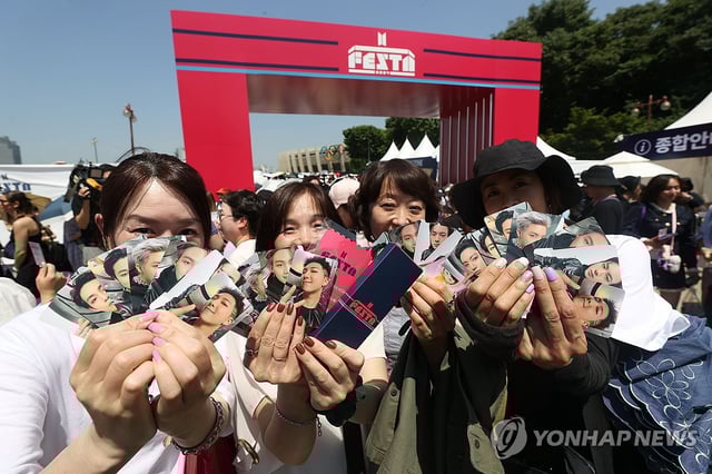 Japanese fans of K-pop boy group BTS show off their photo cards during the 2024 BTS Festa at Jamsil Sports Complex in southern Seoul, in this June 13, 2024, file photo. (Yonhap)
