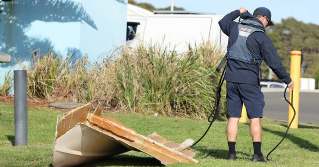 A Maritime NSW official with a large hull section of boat that was pulled ashore at Port Kembla boat ramp on Monday, June 2. Picture by Robert Peet