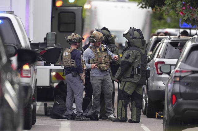 Law enforcement officials dress to investigate after an attack on the Peark Street Mall Sunday, June 1, 2025, in Boulder, Colo. (AP Photo/David Zalubowski)