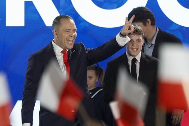 Karol Nawrocki, candidate for the 2025 Polish presidential election supported by Poland&#39;s right-wing Law and Justice (PiS) party, flashes the victory sign in front of supporters as exit polls were announced on tv during their election night event at the Mala Warszawa Theatre in Warsaw, Poland, during the second round of the presidential elections on June 1, 2025.