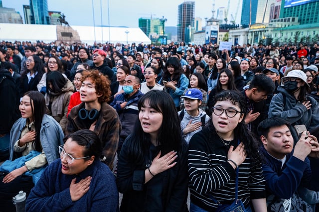 TOPSHOT - People sing during a protest calling for the resignation of Mongolia's Prime Minister Luvsannamsrain Oyun-Erdene over alleged economic mismanagement and corruption involving his family, at Sukhbaatar Square in Ulaanbaatar on May 21, 2025. Hundreds of young Mongolians turned out this week in the country's capital calling for the prime minister's resignation on allegations of corruption, a longstanding source of deep public anger in the landlocked democracy. (Photo by BYAMBASUREN BYAMBA-OCHIR / AFP) (Photo by BYAMBASUREN BYAMBA-OCHIR/AFP via Getty Images)          